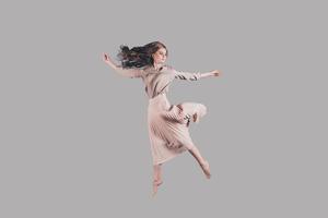 sintiendo la libertad de cada movimiento. foto de estudio de una joven atractiva flotando en el aire