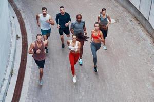 Top view of young people in sports clothing jogging while exercising outdoors photo