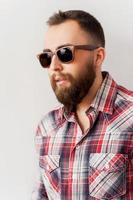 Cool and trendy. Side view of handsome young man in sunglasses looking away photo