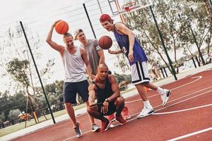 todos sonríen grupo de hombres jóvenes en ropa deportiva tomando selfie y sonriendo mientras están de pie al aire libre foto