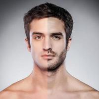 Half shaved. Handsome young man with half shaved face looking at camera while standing against grey background photo