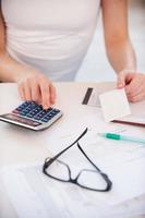 calculando sus gastos. imagen recortada de una mujer calculando sus gastos mientras sostiene una factura foto