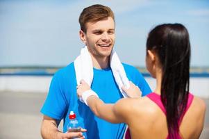 Sporty couple. Young couple in sports clothing standing face to face and smiling photo