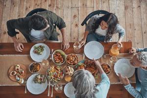 Top view of multi-generation family communicating while having dinner together photo