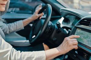 Close up of woman using global positioning system while driving car photo