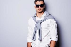 Confident and well-dressed. Handsome young man in smart casual wear looking at camera while standing against grey background photo