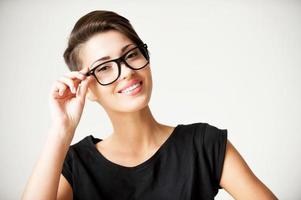Funky style beauty. Beautiful young short hair woman adjusting her glasses and smiling photo
