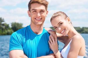 Sporty couple. Beautiful young couple in sports clothing standing together outdoors and smiling photo