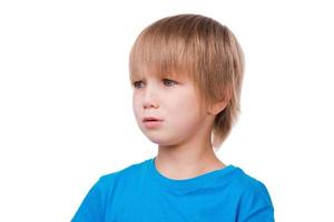 Little boy crying. Sad little boy crying and looking away while standing isolated on white photo