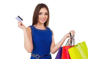 Shopping woman. Laughing young lady holding credit card and shopping bags photo