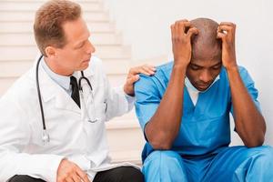 Doctor consoling his colleague. photo
