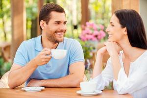 les encanta pasar tiempo juntos. hermosa joven pareja amorosa bebiendo café en un café al aire libre juntos foto