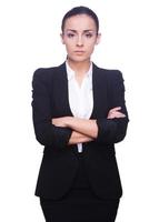 Confident businesswoman. Confident young woman in formalwear looking at camera and keeping arms crossed while standing isolated on white background photo