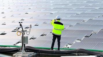 jeune ingénieur prospère avec une tablette numérique à la main qui prévoit d'agrandir l'usine avec des panneaux solaires. video