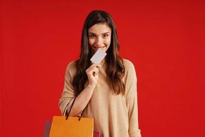 Beautiful young woman in casual clothing carrying shopping bag and credit card photo
