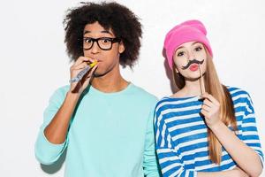 Young and carefree. Funky young couple making faces while standing against white background photo