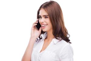 Beauty on the phone. Beautiful young women talking on the mobile phone and smiling while standing against white background photo