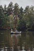 In the wonderful place. Beautiful young couple enjoying romantic date while rowing a boat photo