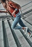 Choosing the right direction. Close-up of young woman in casual wear running up the stairs outdoors photo