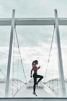 Cardiovascular exercise. Full length of modern young woman in sports clothing jumping while exercising outdoors photo