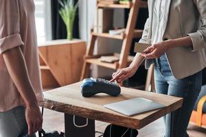 Payments are easy. Close up of salesperson using payment terminal to confirm the purchase while working in the fashion boutique photo