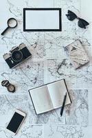 Just travel. High angle shot of sunglasses, photo camera, compass, magnifying glass, diary, smart phone and passport lying on map