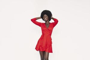 bella joven africana vestida de rojo parada contra el fondo foto
