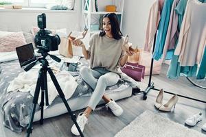 Beautiful young woman in casual clothing making social media video while spending time at home photo