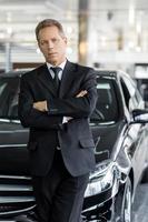 I choose only the best. Confident grey hair man in formalwear standing in front of car and looking at camera photo