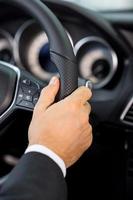 Driving a car. Close-up of male hand on car wheel photo