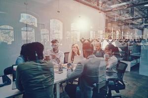 Group of young modern people in smart casual wear discussing business while working in the board room photo