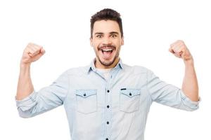 Unleashed fun. Happy young man in shirt gesturing and smiling while standing against white background photo