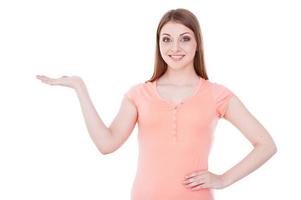 Copy space on her hand. Beautiful young smiling woman holding a copy space and smiling while standing isolated on white photo