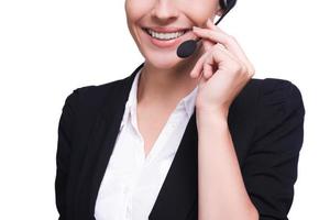 Representante de Servicio al Cliente. imagen recortada de una hermosa joven con auriculares sonriendo mientras está aislada en blanco foto