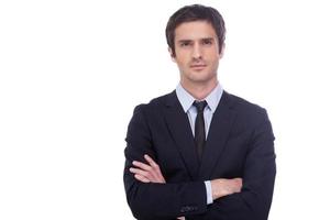 Confident and successful businessman. Handsome young man in formalwear keeping arms crossed and looking at camera while standing isolated on white background photo