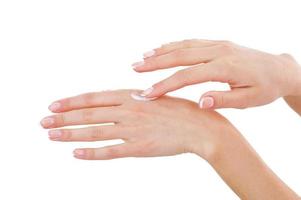 Spreading cream. Close-up of woman applying cream on hand photo