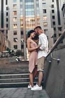 Making each other happy. Full length of beautiful young couple embracing and smiling while standing outdoors photo