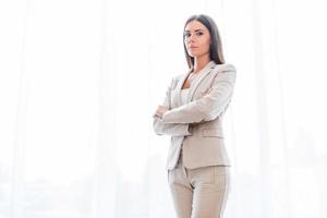 Confident business expert. Confident young businesswoman in suit keeping arms crossed and looking at camera photo