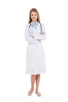 médico confiado. longitud completa de una doctora segura de sí misma con uniforme blanco mirando a la cámara y sonriendo mientras se enfrenta a fondo blanco foto