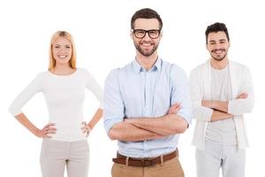 Trust to professionals. Three confident young people in smart casual wear looking at camera and smiling while standing against white background photo