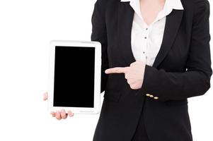 Working on digital tablet. Cropped image of mature businesswoman working on digital tablet while standing isolated on white photo
