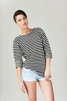 Hip and striped. Fashionable young short hair woman in striped clothing keeping arms crossed and looking at camera photo