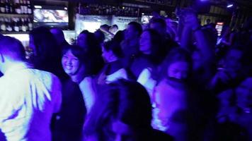 multidão em um show de rock em um bar perto do palco dançando video