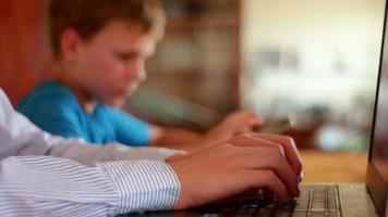 Two Brothers Using Laptop And Ipod On Table At Home video