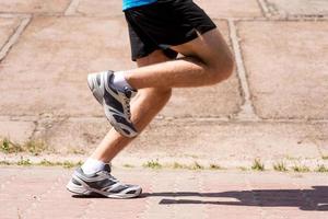 quemando las millas de distancia. imagen de primer plano de vista lateral del hombre corriendo al aire libre foto