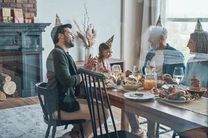 Happy family celebrating birthday of little girl while sitting at the dining table at home photo