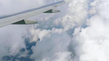 View from the porthole, flight by plane in fluffy white clouds. Beautiful panoramic view from the airplane window video