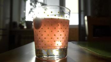 Effervescent tablet in water with bubbles, against influenza, slow motion video