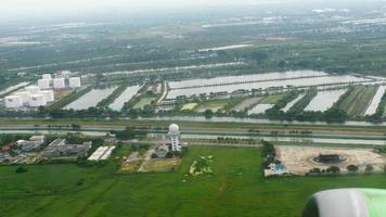 vista da cidade da janela do avião. aeronaves de passageiros sobem após a decolagem do aeroporto suvarnabhumi, tailândia. câmera lenta video