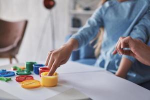 First you choose a color... Close up of little girl touching paints while spending time at home photo